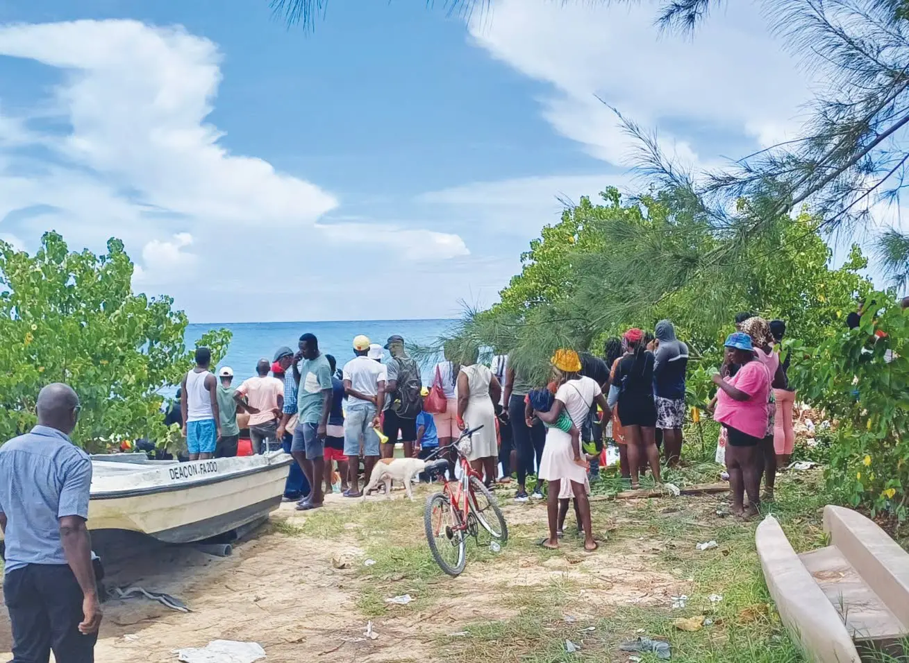 People converge on Falmouth Fishing Beach Tuesday morning after the headless body of 16-year-old Jahmari Reid was taken from the sea. The teen, who was a student at William Knibb Memorial High School, is beileved to have been victim of a shark attack.