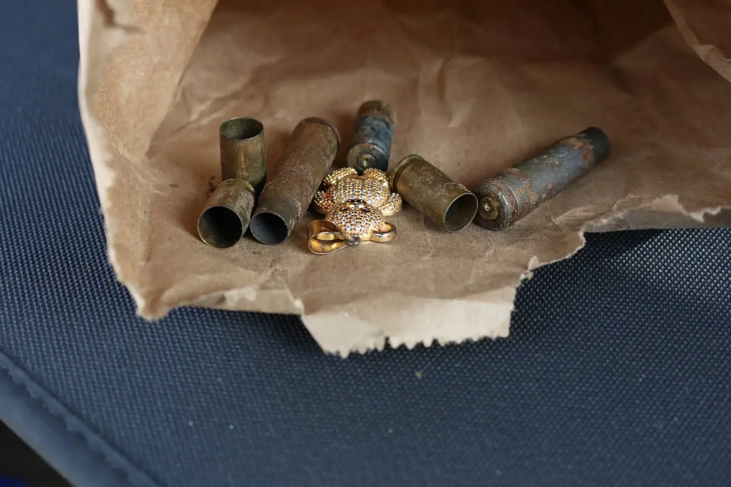 Six spent casings and what appears to be a pendant which were found at the scene of Sunday’s mass murder in Cherry Tree Lane in Clarendon. Llewellyn Wynter