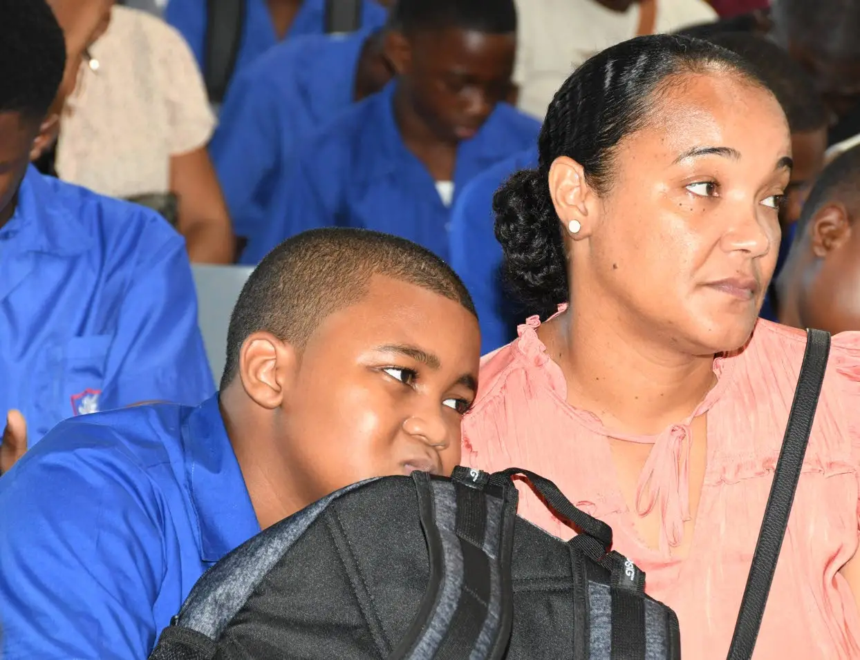 Jamaica College first-former Aiden Awyer leans against his mother Sabrina Palamino during the presentation by Prime Minister Andrew Holness at the school’s devotion on Monday. Joseph Wellington