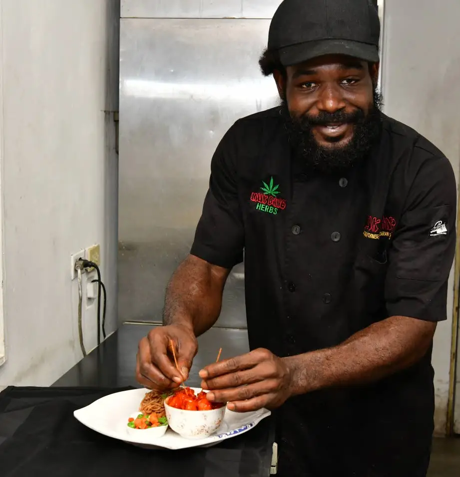 Head chef Oneil McBayne adds the final touches to a sweet and sour chicken dish.Aceion Cunningham